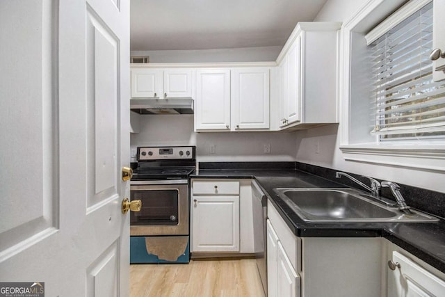 kitchen featuring under cabinet range hood, a sink, dark countertops, stainless steel appliances, and white cabinets