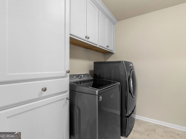 laundry room with baseboards, cabinet space, and separate washer and dryer