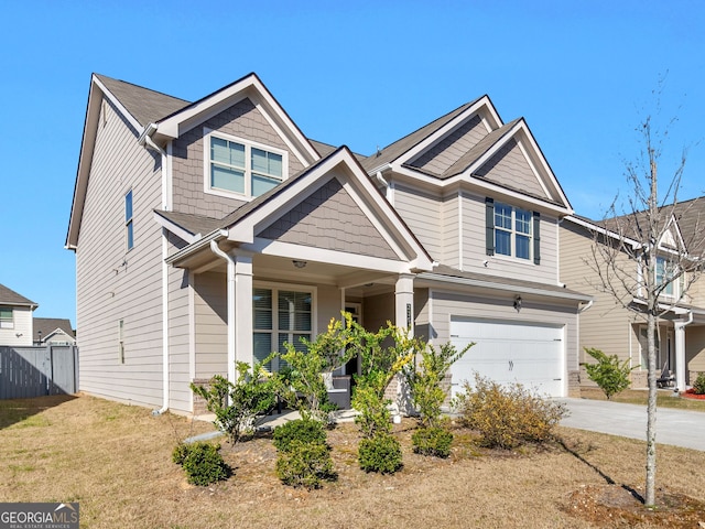 craftsman-style home with an attached garage, fence, and driveway