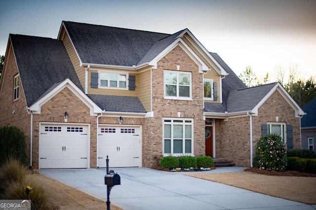 craftsman house featuring brick siding, an attached garage, driveway, and a shingled roof