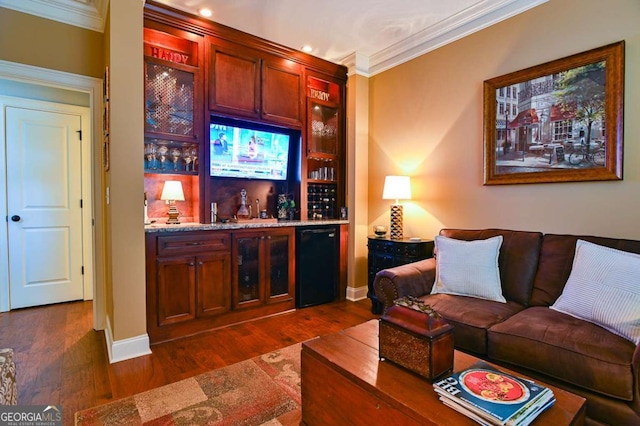 bar with baseboards, dark wood-style flooring, crown molding, fridge, and a dry bar