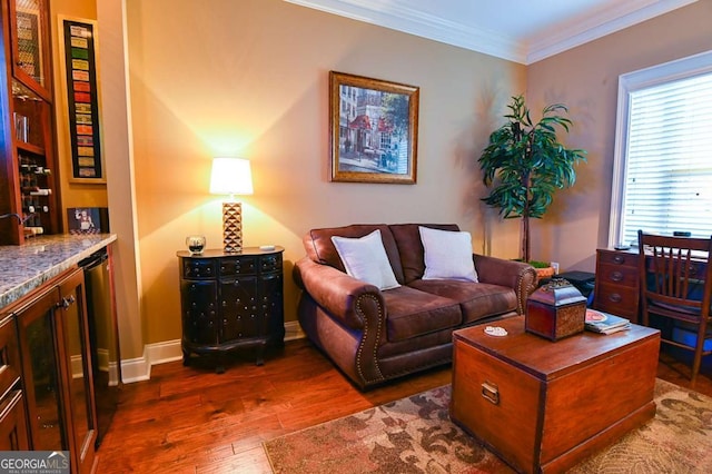 living area with dark wood-type flooring, baseboards, and ornamental molding