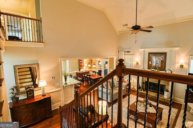 stairway featuring visible vents, wood finished floors, crown molding, baseboards, and ceiling fan