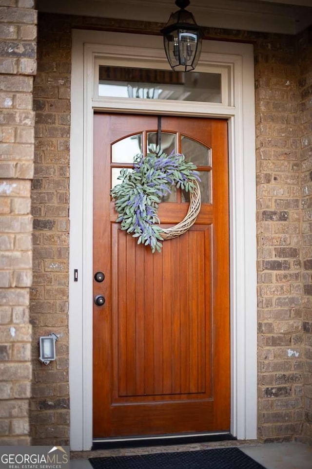 entrance to property featuring brick siding