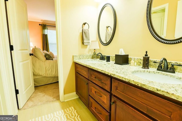 full bath with a sink, double vanity, wood finished floors, and ensuite bathroom