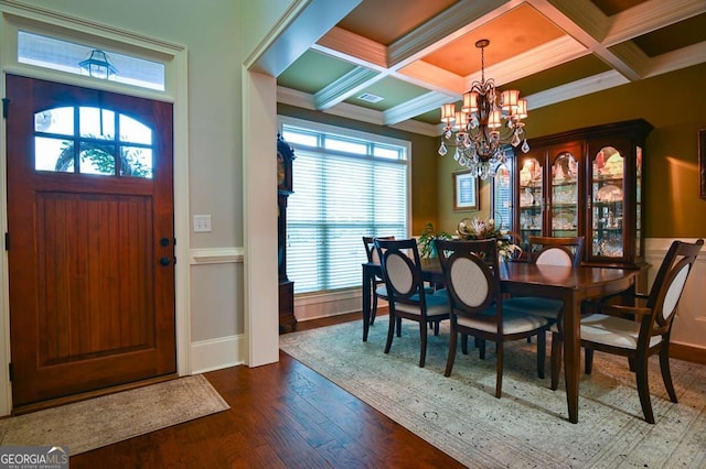 dining room featuring an inviting chandelier, crown molding, dark wood-style flooring, and coffered ceiling