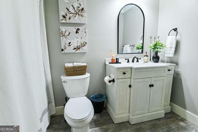 bathroom featuring baseboards, vanity, wood tiled floor, and toilet