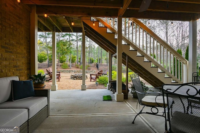 view of patio / terrace with stairway, an outdoor living space, and fence