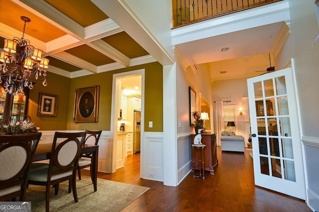 dining room featuring a wainscoted wall, beam ceiling, coffered ceiling, dark wood-style floors, and crown molding