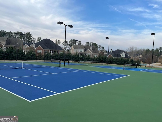 view of sport court with fence and a residential view