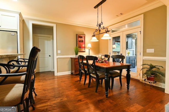 dining room featuring dark wood-type flooring, baseboards, and ornamental molding