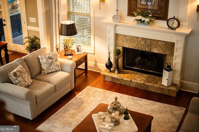 living area featuring baseboards, dark wood finished floors, and a high end fireplace