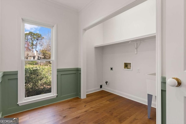washroom featuring ornamental molding, wood finished floors, wainscoting, hookup for an electric dryer, and hookup for a washing machine