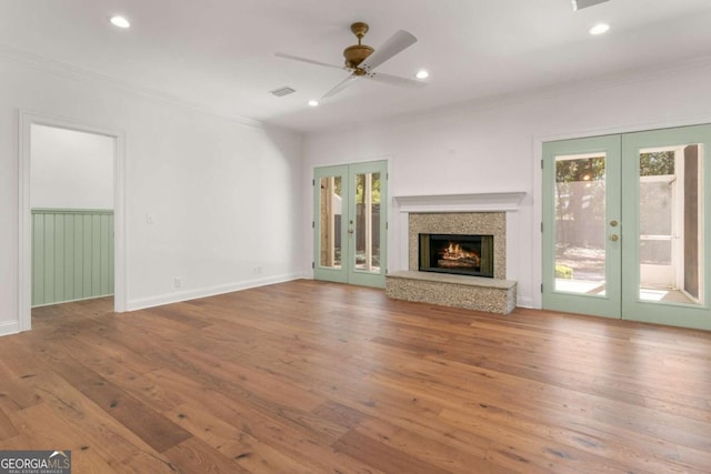 unfurnished living room featuring french doors, wood-type flooring, and ornamental molding