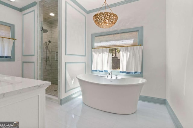 full bathroom with vanity, baseboards, an inviting chandelier, a soaking tub, and a stall shower