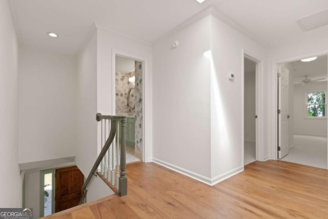 corridor with crown molding, baseboards, an upstairs landing, recessed lighting, and light wood-style flooring