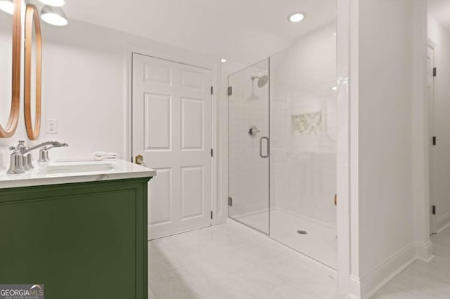 bathroom featuring baseboards, vanity, and a shower stall