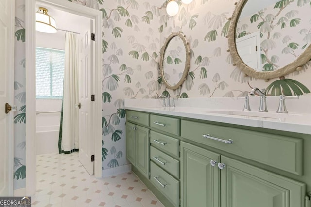 full bath featuring a sink, baseboards, double vanity, and wallpapered walls