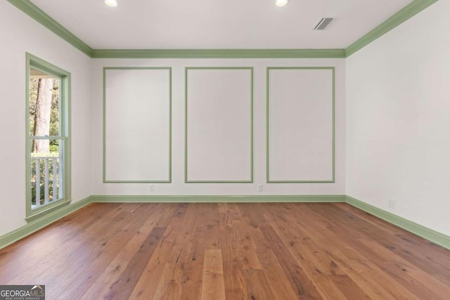 empty room featuring crown molding, recessed lighting, baseboards, and wood-type flooring
