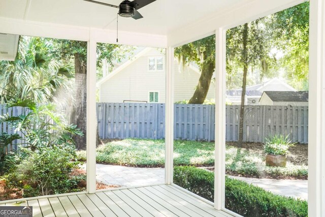 wooden terrace with ceiling fan and fence
