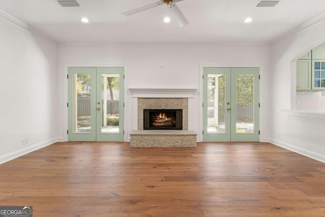 unfurnished living room with wood finished floors, recessed lighting, french doors, and ornamental molding