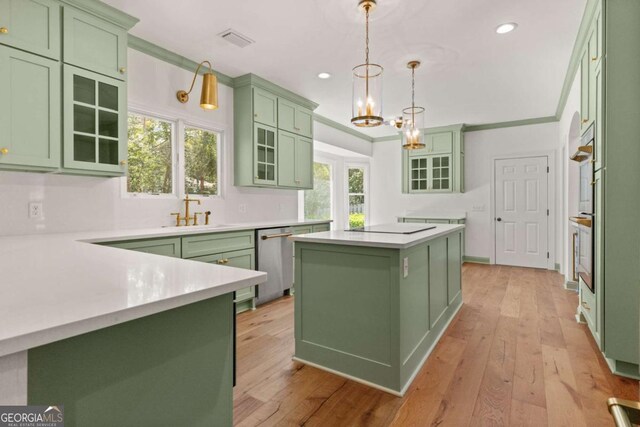 kitchen featuring a sink, appliances with stainless steel finishes, green cabinets, and light countertops
