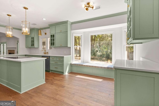 kitchen featuring light countertops, black electric stovetop, light wood-style floors, and green cabinetry