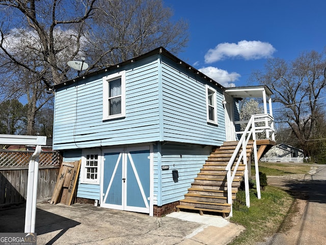 view of front facade featuring stairway and fence