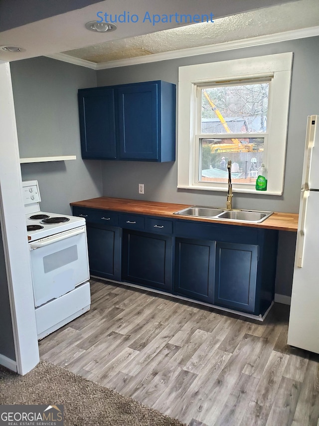 kitchen featuring white appliances, ornamental molding, a sink, wood counters, and blue cabinets