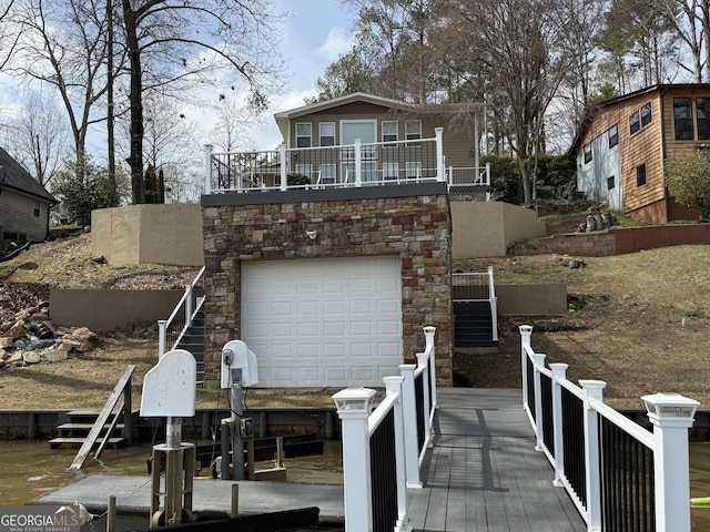 exterior space featuring a balcony, an attached garage, stone siding, and boat lift