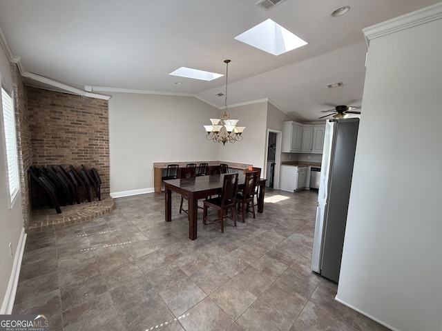 dining space featuring visible vents, baseboards, ornamental molding, lofted ceiling with skylight, and a chandelier