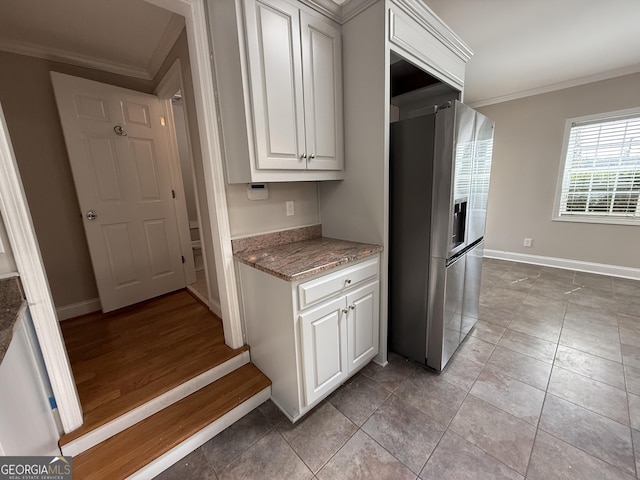 kitchen with light stone counters, baseboards, stainless steel fridge with ice dispenser, and crown molding