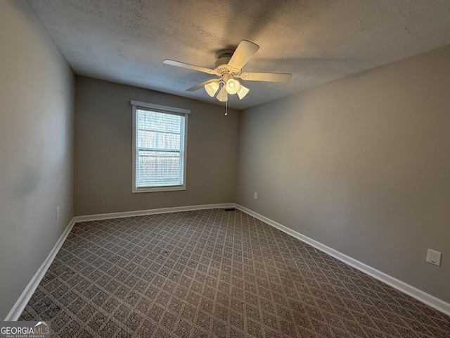 empty room with baseboards, a textured ceiling, ceiling fan, and dark carpet