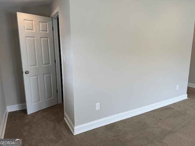 empty room with baseboards and dark colored carpet