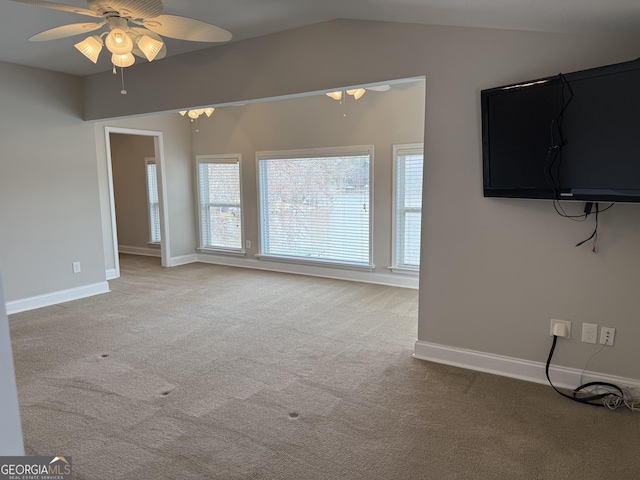 unfurnished living room with baseboards, carpet floors, ceiling fan, and vaulted ceiling