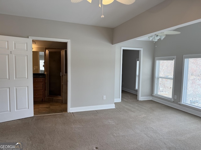 unfurnished bedroom with connected bathroom, baseboards, a ceiling fan, and carpet flooring