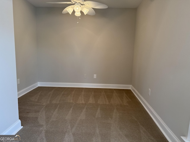 empty room featuring dark carpet, baseboards, and ceiling fan