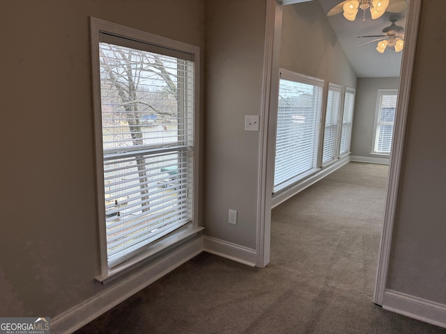 hall featuring lofted ceiling, carpet, and baseboards