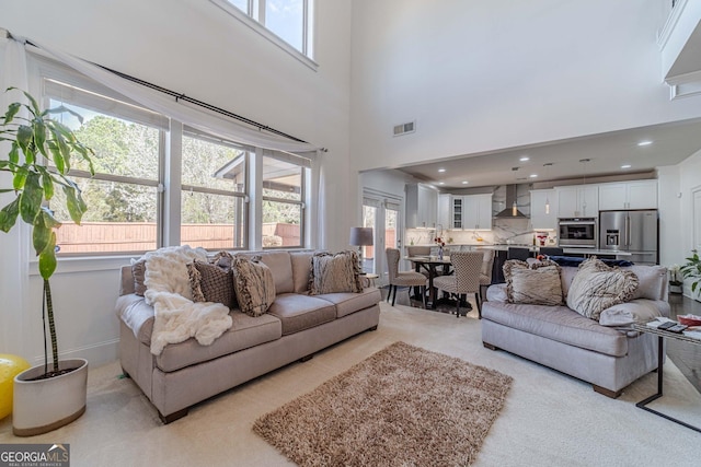 living area featuring a wealth of natural light, visible vents, and recessed lighting