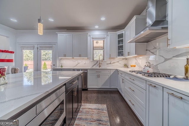 kitchen featuring stainless steel microwave, dark wood finished floors, white cabinets, wall chimney exhaust hood, and a sink