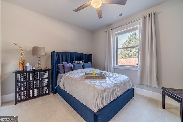 bedroom with visible vents, baseboards, light colored carpet, and ceiling fan