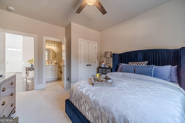 bedroom featuring a ceiling fan, lofted ceiling, a sink, light carpet, and connected bathroom