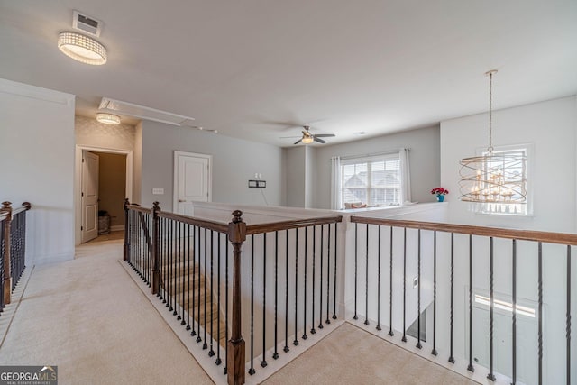 hall with attic access, carpet flooring, an upstairs landing, and visible vents