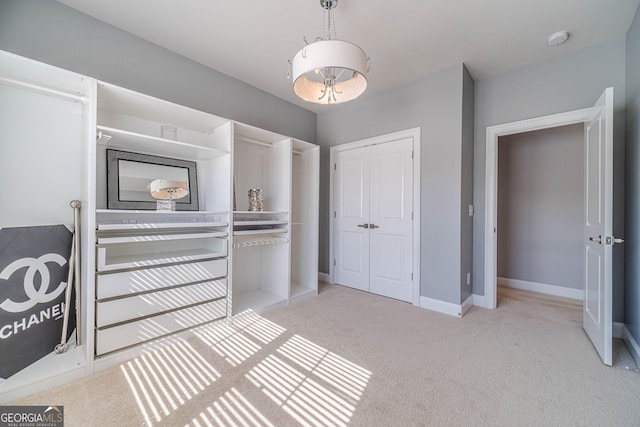 interior space with a closet, baseboards, and light colored carpet