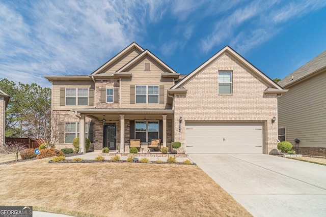 craftsman inspired home with brick siding, a front lawn, concrete driveway, covered porch, and a garage