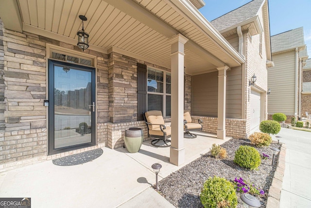 property entrance featuring stone siding, driveway, a porch, and an attached garage