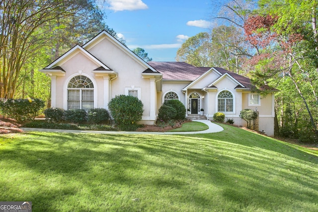 view of front of house with stucco siding and a front yard