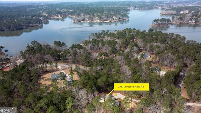 aerial view featuring a water view and a wooded view