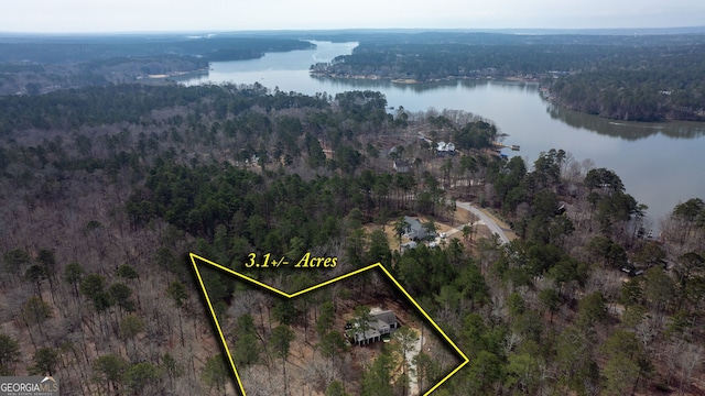 drone / aerial view featuring a wooded view and a water view