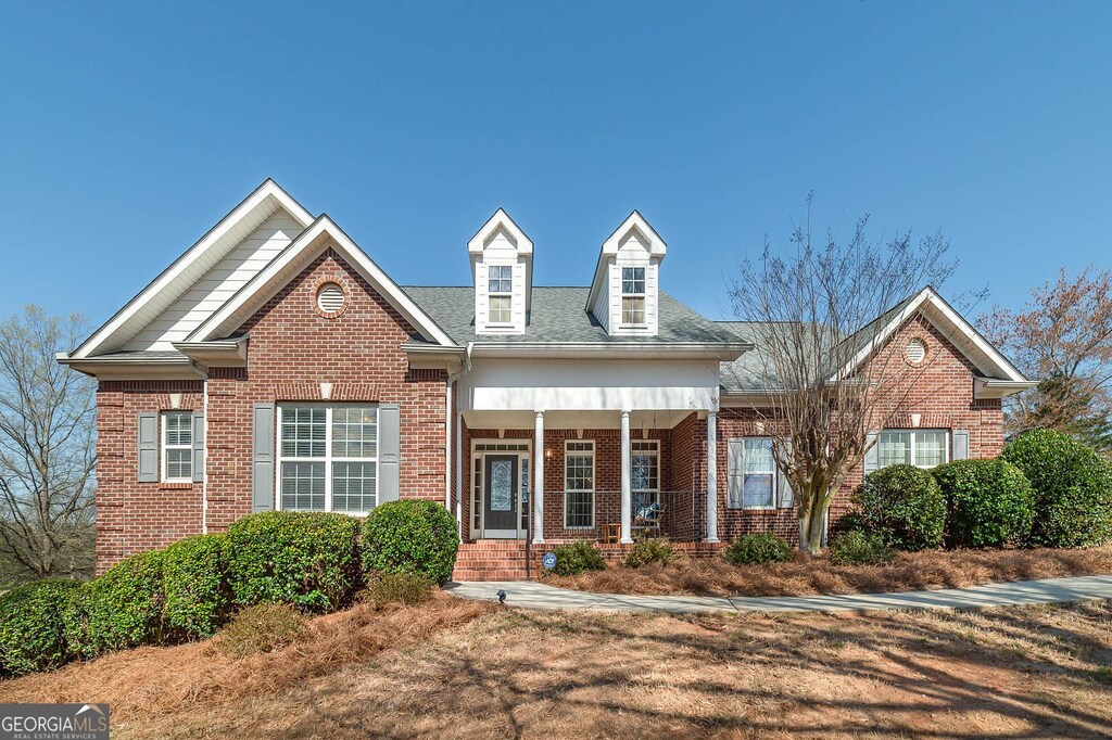 view of front of house featuring brick siding and a porch
